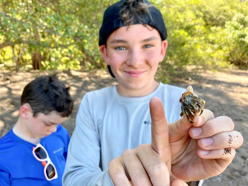 Boys catching hermit crabs at Playa Honda in Guanacaste, Costa Rica